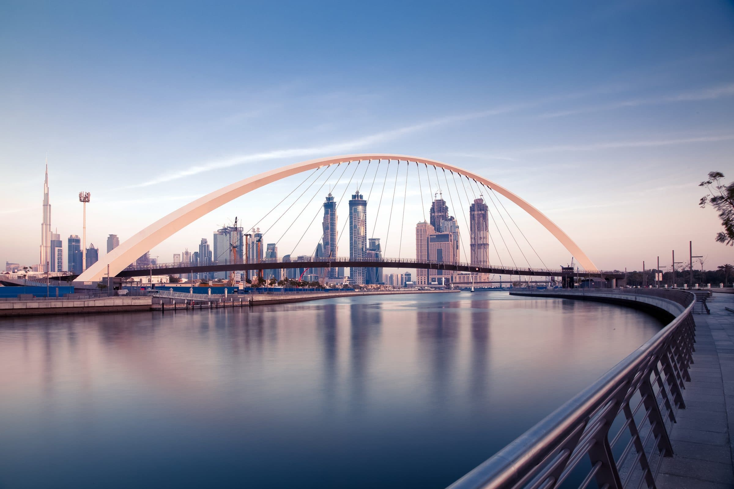 Dubai Water Canal bridge with the Burj Khalifa at sunrise